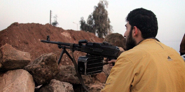 ALEPPO, SYRIA - JANUARY 4: A man holds his rifle during clashes between the Free Syrian Army (FSA) and the Islamic State of Syria and Al-Sham (or ISIS) on January 4, 2014 in Aleppo, Syria. (Photo by Salih Mahmud Leyla/Anadolu Agency/Getty Images)