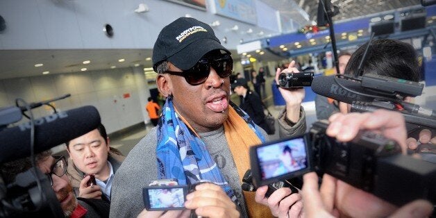 Former US NBA basketball player Dennis Rodman (C) speaks to members of the media as he makes his way through Beijing's international airport on December 19, 2013. Rodman is on a visit to North Korea from December 19 to 23. AFP PHOTO / WANG ZHAO (Photo credit should read WANG ZHAO/AFP/Getty Images)