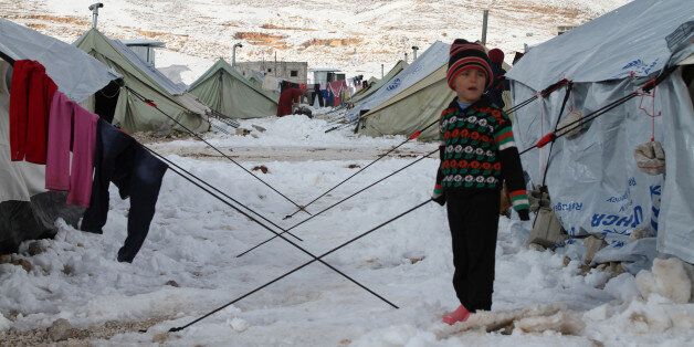 A Syrian child stands in the snow in a refugee camp in the town of Arsal in the Lebanese Bekaa valley on December 13, 2013. Thousands of Syrian refugees living in makeshift camps in Lebanon were weathered a winter storm that brought snow, rain and freezing temperatures to the country. AFP PHOTO/STR (Photo credit should read -/AFP/Getty Images)