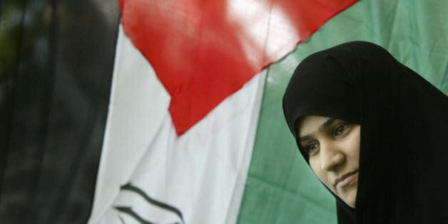 TEHRAN, IRAN: An Iranian woman stands in front of a Palestinian flag during a protest outside the UN building in Tehran, 17 May 2005. Some 150 Iranian cleric students protested to denounce attempts by Jewish extremists to enter Jerusalem's al-Aqsa mosque compound. AFP PHOTO/BEHROUZ MEHRI (Photo credit should read BEHROUZ MEHRI/AFP/Getty Images)