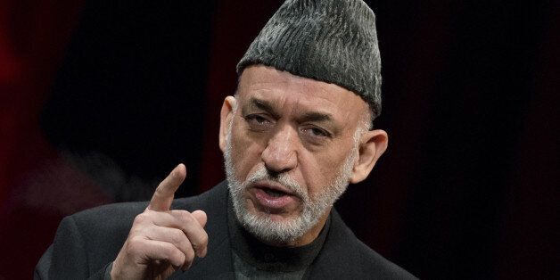 Afghan President Hamid Karzai gestures as he attends the opening ceremony of a private media company in Kabul on January 21, 2014. AFP PHOTO/JOHANNES EISELE (Photo credit should read JOHANNES EISELE/AFP/Getty Images)