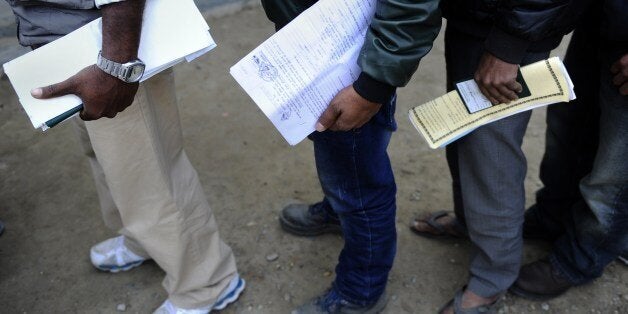 Nepalese migrant workers queue to receive official documents in order to leave Nepal from the Labour department in Kathmandu