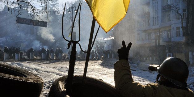An anti-government protester uses binoculars to look at police troops at a barricade on Grushevsky street in Kiev, on February 4, 2014. The crisis has sparked tensions between the West, which is considering sanctions against Ukrainian officials, and Russia, which has accused the EU and US of interference in Ukraine. AFP PHOTO/GENYA SAVILOV (Photo credit should read GENYA SAVILOV/AFP/Getty Images)