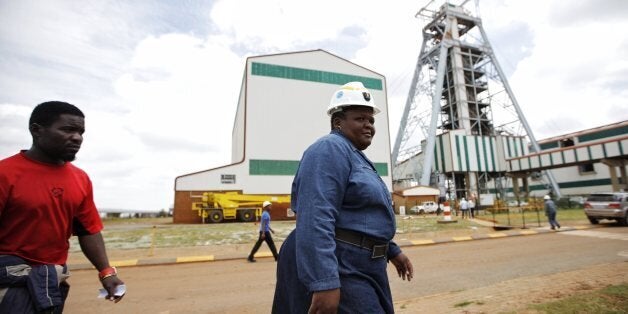 Employees arrive at the Gold Mine in Doornkop west of Johannesburg on February 5, 2014, where a mining accident happened yesterday evening leaving nine miners trapped underground. The fire broke out about 1.7 kilometres (over one mile) beneath the surface at the Doornkop mine on February 4, 2014 and may have been triggered by a seismic event. AFP PHOTO/MARCO LONGARI (Photo credit should read MARCO LONGARI/AFP/Getty Images)