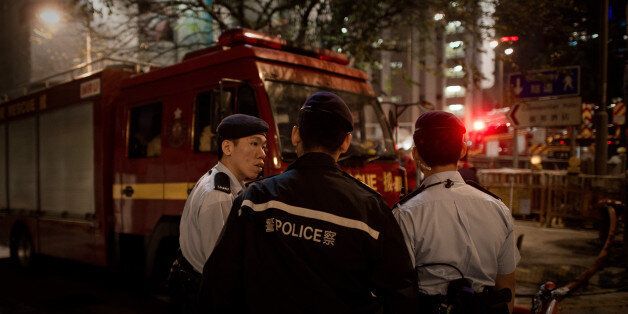 Policemen are seen near the site where a World War II-era bomb weighing almost a tonne was discovered in Hong Kong on February 6, 2014. More than 2,000 people were evacuated and roads closed in central Hong Kong where the bomb was discovered at a construction site, police said. AFP PHOTO / Philippe Lopez (Photo credit should read PHILIPPE LOPEZ/AFP/Getty Images)