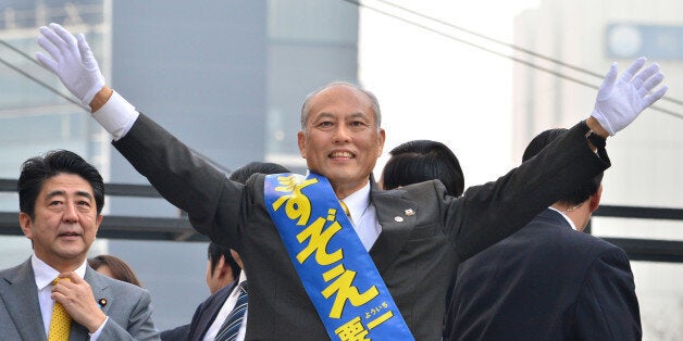 Japan's former health minister and current candidate for the Tokyo gubernatorial election Yoichi Masuzoe (C) waves during his election campaign in Tokyo on February 2, 2014. Observers say the election on February 9 will be a two-horse race between the anti-nuclear former prime minister Morihiro Hosokawa and Yoichi Masuzoe, an academic and former health minister, who served as a member of a Liberal Democratic Party (LDP) government. AFP PHOTO / KAZUHIRO NOGI (Photo credit should read KAZUHIRO NOGI/AFP/Getty Images)