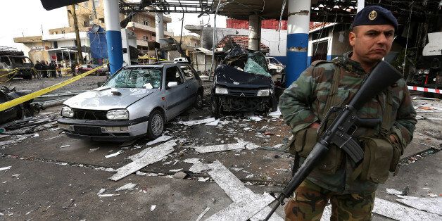 A Lebanese army soldier, stand guard at the site of a deadly car bomb that exploded Saturday evening near a gas station, in the predominately Shiite town of Hermel, about 10 miles (16 kilometers) from the Syrian border in northeast Lebanon, Sunday, Feb. 2, 2014. A shadowy Lebanese Sunni extremist group late Saturday claimed responsibility for a suicide car bombing in Hermel, a stronghold of Lebanon's militant Hezbollah group, that killed several people in the latest attack linked to the war in neighboring Syria. (AP Photo/Hussein Malla)