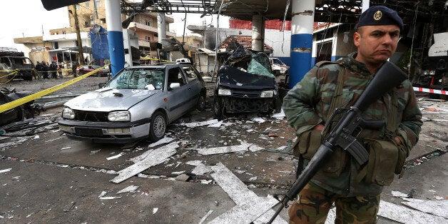 A Lebanese army soldier, stand guard at the site of a deadly car bomb that exploded Saturday evening near a gas station, in t
