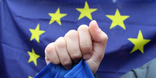 People hold an EU flag on November 24, 2013 during a rally in Kiev. Pro-West Ukrainians on November 24 staged the biggest protest in Kiev since the 2004 Orange Revolution, demanding that the government sign a key pact with the European Union and clashing with police. The opposition called the rally after President Viktor Yanukovych's government reversed a plan to sign a historic deal deepening ties with the European Union, in a U-turn critics said was forced by the Kremlin. AFP PHOTO/ ALEXANDER KHUDOTEPLY (Photo credit should read Alexander KHUDOTEPLY/AFP/Getty Images)