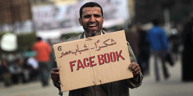 CAIRO, EGYPT - FEBRUARY 03: An anti-government demonstrator holds a sign during clashes on February 3, 2011 in Cairo, Egypt. Initial protests against the government were organized on internet social media. The Egyptian army positioned tanks between the protesters during a second day of violent skirmishes in and around Tahrir Square in Cairo. (Photo by John Moore/Getty Images)