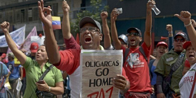 People shout slogans during a farmers rally in support of the government of Venezuelan President Nicolas Maduro in Caracas on February 26, 2014. Venezuela's opposition refused Wednesday to take part in talks that were called by the government in a bid to halt three weeks of protests that have left 14 dead and raised alarm in South America, the United States and Europe. AFP PHOTO/ Raul ARBOLEDA (Photo credit should read RAUL ARBOLEDA/AFP/Getty Images)