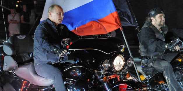 Russian Prime Minister Vladimir Putin (L) rides a motorbike as he takes part in the 16th annual motorbike festival held by 'The Night Wolves' youth organization in the southern Russian town of Novorossiysk, on August 29, 2011. AFP PHOTO / RIA NOVOSTI / POOL / ALEXEY DRUZHININ (Photo credit should read ALEXEY DRUZHININ/AFP/Getty Images)