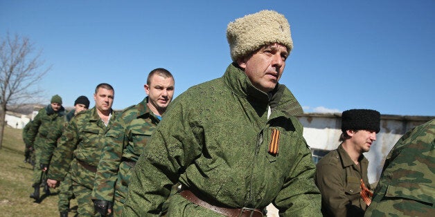 PEREVALNE, UKRAINE - MARCH 03: A unit claiming to Cossack and other citizen pro-Russian volunteers arrive to take up position outside a Ukrainian miltary base where heavliy-armed unidentifed soldiers have surrounded Ukrainian soldiers inside in Crimea on March 3, 2014 in Perevalne, Ukraine. Scores of heavily-armed soldiers not displaying any idenifying insignia have taken up positions outside the base and parked several dozen vehicles, mostly trucks and patrol cars, nearby. Their commander has reportedly told the Ukrainian unit to hand over the base and come out without any weapons, though the Ukrainians have thus far refused. Soldiers have blockaded several Ukrainian military bases across Crimea in recent days as pro-Russian forces are cementing their seizure of authority in the peninsula. (Photo by Sean Gallup/Getty Images)