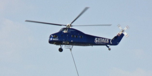 On a windy Saturday morning, we were sitting outside (sheltered from the relentless wind) having our morning beverages when we became aware of the sound of a helicopter droning away. I had to go find it. Sure enough, it was doing aerial crane duty moving items perhaps 300 yards from one spot to another in a warehousing area.