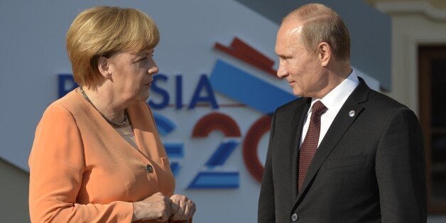 Russias President Vladimir Putin welcomes Germanys Chancellor Angela Merkel at the start of the G20 summit on September 5, 2013 in Saint Petersburg. Russia hosts the G20 summit hoping to push forward an agenda to stimulate growth but with world leaders distracted by divisions on the prospect of US-led military action in Syria. AFP PHOTO / ERIC FEFERBERG (Photo credit should read ERIC FEFERBERG/AFP/Getty Images)