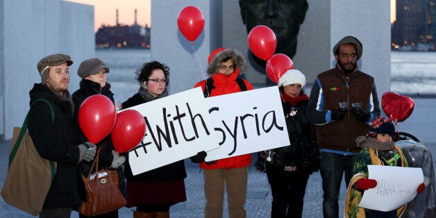 WASHINGTON, DC - MARCH 13 : Activists hold red balloons and signs during the 'With Syria' campaign to mark the third anniversary of the start of the Syrian conflict at Roosevelt Island's FDR Four Freedoms Park in New York City, on March 13, 2014. Activicts around the world take part in the 'With Syria' campaign to mark the third anniversary of the devastating civil war and call for an end of the conflict in Syria. (Photo by Bilgin Sasmaz/Anadolu Agency/Getty Images)