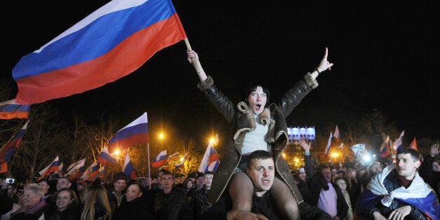 Pro-Russian Crimeans celebrate in Sevastopol on March 16, 2014 after partial showed that about 95.5 percent of voters in Ukraine's Crimea region supported union with Russia. Crimeans voted overwhelmingly to join former political master Russia as tensions soared in the east of the splintered ex-Soviet nation amid the worst East-West crisis since the Cold War. AFP PHOTO/ VIKTOR DRACHEV (Photo credit should read VIKTOR DRACHEV/AFP/Getty Images)