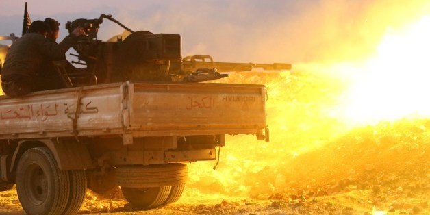 Rebel fighters fire a heavy machine gun at the government forces Al-Samman checkpoint on a road leading to Idlib near the Syr