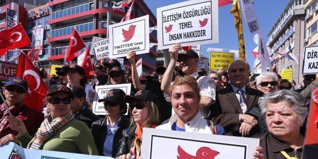 Protesters hold placards reading 'do not touch my twitter ' and 'communication right is a basic human right' during a demonstration against the ban on Twitter during a demonstration against Turkish government in Ankara on March 22, 2014. Placards read, 'do not touch my twitter ', 'communication rught is a basic human right' (back R). Turkey's government on Saturday defended its internationally condemned ban on Twitter as a 'preventive measure' to stop 'character assassinations' following a wave of corruption investigation leaks. AFP PHOTO/ADEM ALTAN (Photo credit should read ADEM ALTAN/AFP/Getty Images)