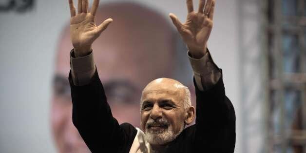 Afghan presidential candidate Ashraf Ghani gestures towards a crowd in an assembly hall in Kabul on Februray 13, 2014. Ghani