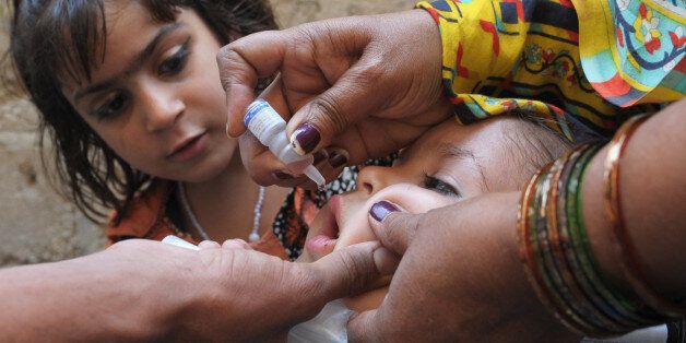 A Pakistani health worker administers polio vaccine drops to a child during a polio vaccination campaign in Karachi on March 9, 2014. Pakistan is one of only three countries in the world where the crippling virus is still endemic, along with Afghanistan and Nigeria. AFP PHOTO/Rizwan TABASSUM (Photo credit should read RIZWAN TABASSUM/AFP/Getty Images)