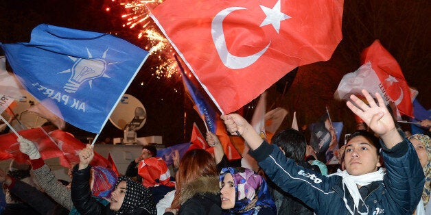 ANKARA, TURKEY - MARCH 31: Supporters of the ruling Justice and Development Party wave flags as they listen to the speech of Turkey's Prime Minister Recep Tayyip Erdogan (not seen) outside the party's headquarters in Ankara, Turkey on March 31, 2014. According to early unofficial results, the ruling Justice and Development Party received 47 percent of the votes, with nearly 43 percent of ballot boxes having been opened across the country. (Photo by Mahmut Serdar Alakus/Anadolu Agency/Getty Images)