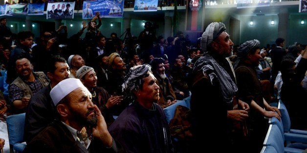 A ray of late afternoon light shines on Afghan men listening to a presidential candidate during a speech at a local hall on A