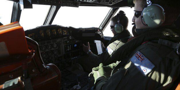 Australian flight engineer Sargent Jush Rumis (R), on board a Royal Australian Air Force AP-3C Orion, keeps a look out in the cockpit as they search for missing Malaysia Airlines flight MH370 debris or wreckage in the southern Indian Ocean on March 22, 2014. The Orion under took a four-hour journey to search an area approximately 2,500 kms southwest of Perth, two hours on station searching at about 400 feet above the ocean, and then a four-hour return. China released on March 22 a new satellite image of a large floating object possibly linked to missing Malaysia Airlines flight MH370, boosting search efforts as anger with the pace of the operation boiled over among Chinese relatives in Beijing. AFP PHOTO / POOL / Rob Griffith (Photo credit should read ROB GRIFFITH/AFP/Getty Images)