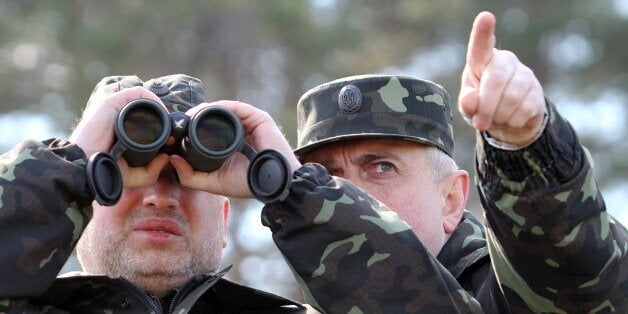 Acting Minister of Defence of Ukraine Michail Koval (R) and Olexander Turchynov, speaker of the parliament and the interim president, attend military exercises on the shooting range in Desna, Chernigiv region on April 2, 2014. Russia on Wednesday accused NATO of succumbing to 'Cold War' instincts after the alliance suspended all cooperation with Moscow over the Crimea crisis. AFP PHOTO/ PRESIDENTIAL PRESS-SERVICE HAND OUT/ MYKHAYLO MARKIV (Photo credit should read MYKHAYLO MARKIV/AFP/Getty Images)