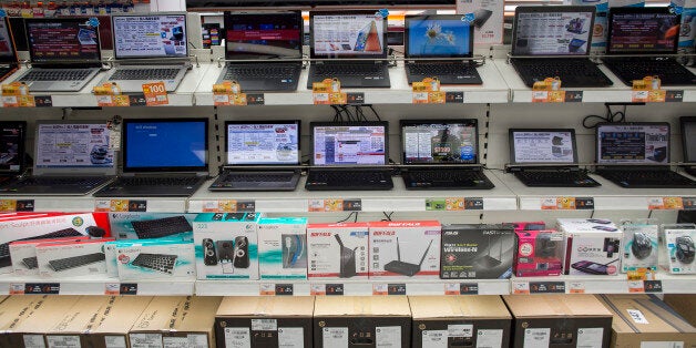 Lenovo Group Ltd. laptop computers are displayed on shelves above routers, keyboards and speakers in a Fortress electronics s