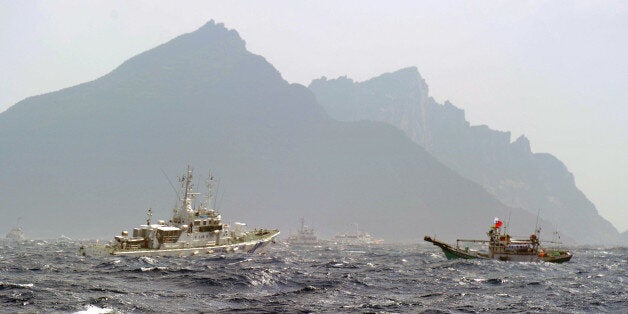 A Taiwan fishing boat (R) is blocked by a Japan Coast Guard (L) vessel near the disputed Diaoyu / Senkaku islands in the East