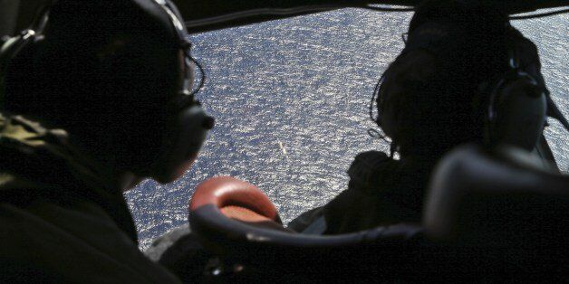 Crew member look out the cockpit windows of a RNZAF P3 Orion during search operations for wreckage and debris of missing Malaysia Airlines Flight MH370 in the Southern Indian Ocean, near the coast of Western Australia on April 4, 2014. A US Navy 'black box' detector made its much-anticipated debut in the oceanic hunt for flight MH370 on April 4 but Australia's search chief warned it was crunch time with the box's signal set to expire soon. AFP Photo/Nick Perry/Pool (Photo credit should read Nick Perry/AFP/Getty Images)