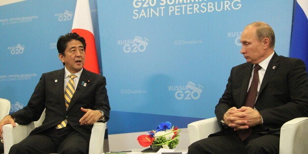 SAINT PETERSBURG - SEPTEMBER 05: Russian President Vladimir Putin (R) greets Japanese Prime Minister Shinzo Abe (L) at the G20 summit on September 5, 2013 in St. Petersburg, Russia. The G20 summit is expected to be dominated by the issue of military action in Syria while issues surrounding the global economy, including tax avoidance by multinationals, will also be discussed duing the two-day summit. (Photo by Sasha Mordovets/Getty Images)