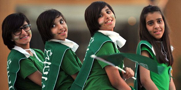 Saudi girls wear the national flag across their shoulders during celebrations marking the 83rd Saudi Arabian National Day in the desert kingdom's capital Riyadh, on September 23, 2013. AFP PHOTO/FAYEZ NURELDINE (Photo credit should read FAYEZ NURELDINE/AFP/Getty Images)