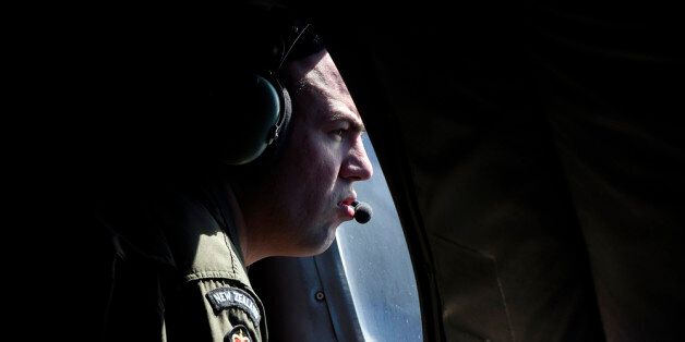 AT SEA - APRIL 11: A crew member looks out an observation window aboard a Royal New Zealand Air Force (RNZAF) P3 Orion maratime search aircraft as it flies over the southern Indian Ocean looking for debris from missing Malaysian Airlines flight MH370 on April 11, 2014 At Sea. Search and rescue officials in Australia are confident they know the approximate position of the black box recorders from missing Malaysia Airlines Flight MH370, Australian Prime Minister Tony Abbott said on Friday. At the same time, however, the head of the agency coordinating the search said that the latest 'ping' signal, which was captured by a listening device buoy on Thursday, was not related to the plane. (Photo by Richard Polden - Pool/Getty Images)