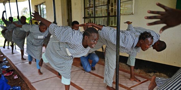 Female prisoners, part of the Wapendanao self-help group, practice yoga inside Nairobi's Langata Women's Maximum Security Prison on May 14, 2013. The women are all HIV positive and are instructed under The Africa Yoga Project (AYP), a non-profit organisation set up by an American in 2007 with the aim of using yoga as a tool for social change. AFP PHOTO/Carl de Souza (Photo credit should read CARL DE SOUZA/AFP/Getty Images)
