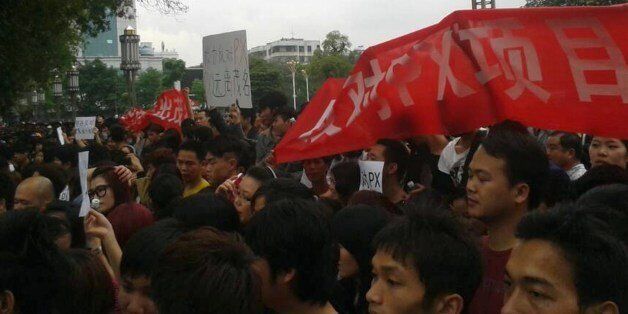 This picture taken with a mobile phone on April 3, 2014 shows protesters rallying against a plant producing paraxylene (PX) in front of the government headquarters in Maoming, south China's Guangdong province. Chinese police have detained 18 people over large rallies opposing a chemical plant in Maoming, state-run media reported on April 4, as locals said the protests had entered a fifth day. CHINA OUT AFP PHOTO (Photo credit should read STR/AFP/Getty Images)
