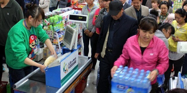 This picture taken on April 11, 2014 shows people buying bottled water in a supermarket in Lanzhou, northwest China's Gansu province. Tap water in a Lanzhou was found to contain excessive levels of the toxic chemical benzene, prompting residents to ruch to buy bottled water, state media said on April 11. CHINA OUT AFP PHOTO (Photo credit should read STR/AFP/Getty Images)