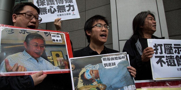 HONG KONG - FEBRUARY 27: Pro-democracy activists hold a sign with an image of former chief editor of the Ming Pao daily Kevi