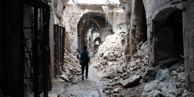 A rebel fighter walks in a devastated alley of Aleppo's old market, in the UNESCO-listed northern Syrian city on February 27,