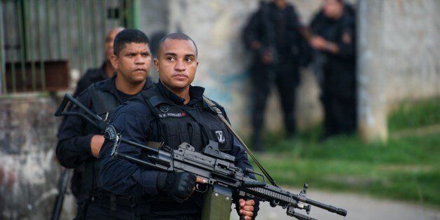 PM paramilitary police BOPE special unit personnel patrol during a police operation to 'pacify' the Vila Kennedy shantytown in Rio de Janeiro, Brazil on March 13 , 2014, Brazil. A 270-strong police force Thursday occupied a favela in western Rio riven by drug violence, as authorities pursue their pre-World Cup crime crackdown. AFP PHOTO/CHRISTOPHE SIMON (Photo credit should read CHRISTOPHE SIMON/AFP/Getty Images)