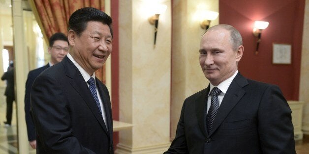 Russia's President Vladimir Putin (R) shakes hands with his Chinese counterpart Xi Jinping before a reception to greet high-ranked foreign guests before the 2014 Winter Olympic Games opening ceremony in Sochi, on February 7, 2014.AFP PHOTO/ RIA-NOVOSTI/ POOL / ALEXEI NIKOLSKY (Photo credit should read ALEXEI NIKOLSKY/AFP/Getty Images)