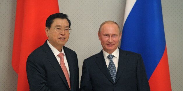 Russia's President Vladimir Putin (R) shakes hands with Chinese National People's Congress Chairman, Zhang Dejiang, during their meeting in Putin's residence Bocharov Ruchei in the Russian Black Sea resort of Sochi, on September 23, 2013. AFP PHOTO/ RIA-NOVOSTI/ POOL / ALEXEY DRUZHININ (Photo credit should read ALEXEY DRUZHININ/AFP/Getty Images)