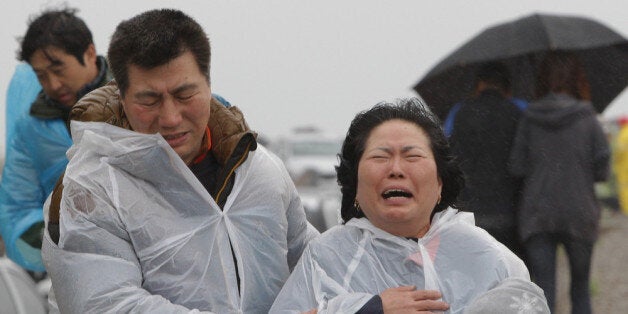 JINDO-GUN, SOUTH KOREA - APRIL 17: A relative weeps as she waits for missing passengers of a sunken ferry at Jindo gymnasium on April 17, 2014 in Jindo-gun, South Korea. Six are dead, and 290 are missing as reported. The ferry identified as the Sewol was carrying about 470 passengers, including the students and teachers, traveling to Jeju Island. (Photo by Chung Sung-Jun/Getty Images)