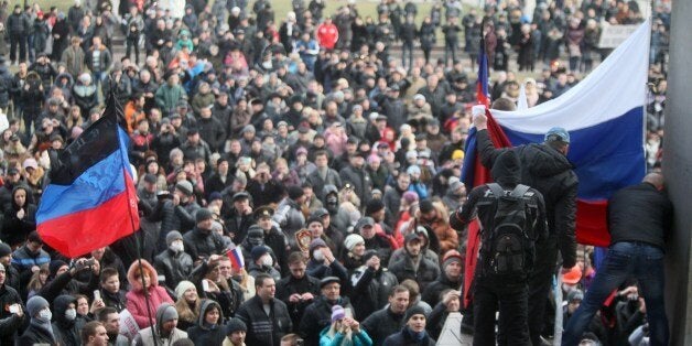 Pro-Russian protesters raise a Russian flag in front of the regional administration building during a rally in the industrial Ukrainian city of Donetsk on March 1, 2014. More than 10,000 people carrying Russian flags protested in the eastern Ukrainian city of Donetsk, the stronghold of ousted president Viktor Yanukovych. Protesters declared they supported 'the aspirations of Crimea to rejoin Russia', referring to Ukraine's pro-Russia peninsula further south where Kiev has accused Moscow of launching an 'armed invasion.' AFP PHOTO/ ALEXANDER KHUDOTEPLY (Photo credit should read Alexander KHUDOTEPLY/AFP/Getty Images)