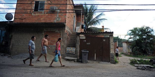 Residents of Vila Autodromo shantytown walk in the street on August 17, 2012 in Rio de Janeiro. The president of the Association of Residents of Vila Autodromo shantytown, Altair Guimaraes, reported the eviction of more than 3,000 shantytown residents for the construction of the Olympic Park and Villa for the 2016 Olympic Games. AFP PHOTO/VANDERLEI ALMEIDA (Photo credit should read VANDERLEIALMEIDA/AFP/GettyImages)