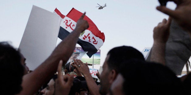 CAIRO, EGYPT - JULY 5: Supporters of former Egyptian President Mohammed Morsi demonstrate in front of the headquarters of the Egyptian Republican Guard in Nasr City as an Apache attack helicopter flies overhead on July 5, 2013 in Cairo, Egypt. A number of protesters were reported killed after Egyptian soldiers opened fire on the supporters of former Egyptian president, They had marched on the headquarters of the Republican Guard after midday prayers at a nearby mosque, after it was rumored that the deposed Morsi, was being held under arrest by the military inside the Republican Guard headquarters in Cairo. (Photo by Ed Giles/Getty Images).