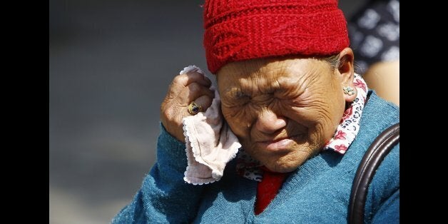 Mother of Nepalese mountaineer Ang Kaji Sherpa, killed in an avalanche on Mount Everest, cries while she waits for his body a