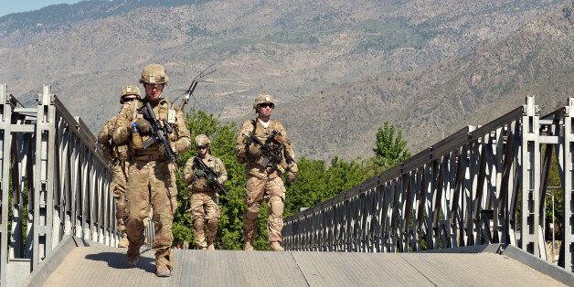 US soldiers of the 2nd Platoon Alfa Company of Combined Team Bastogne, 1st Brigade Combat Team, 101st Airborne Division (Air Assault) keep a watch over the Shamirkot Bridge built over the Watahpur river during a visit by the Provincial Reconstruction Team (PRT) to the bridge near the forward base Honaker Miracle in Kunar province on April 14, 2013. The PRT visited the Shamirkot Bridge to make an assessment of its reconstruction. AFP PHOTO/Manjunath KIRAN (Photo credit should read Manjunath Kiran/AFP/Getty Images)