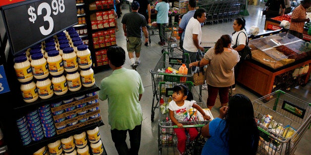 Customers wait in line to check out during the grand opening of a Wal-Mart Stores Inc. location in Panorama City, California, U.S., on Friday, Sept. 28, 2012. Wal-Mart Stores Inc., the world?s largest retailer, will hire more than 50,000 temporary workers in its U.S. stores for the holiday shopping season. Photographer: Patrick T. Fallon/Bloomberg via Getty Images